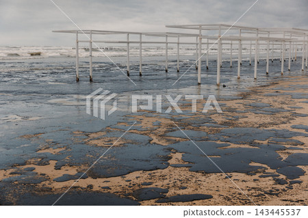 Beach and sea polluted with oil. Beach oil fuel spill impact, pollution, waste disposal. Beach and sea polluted with oil. Beach oil fuel spill impact, pollution, waste disposal. 143445537