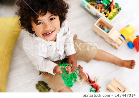 Portrait, boy and kid on floor with toys to relax in living room for child development or playing games in home. Face, apartment and male toddler with fun, smile and top view for weekend activity Portrait, boy and kid on floor with toys to relax in living room for child development or playing games in home. Face, apartment and male toddler with fun, smile and top view for weekend activity 143447014