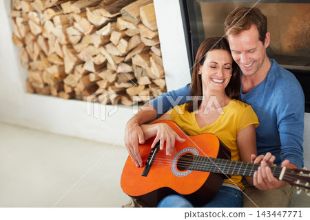Couple, guitar and smile for music on floor in home with bonding, connection and art in living room. Man, woman and musician with teaching, listen and creativity with instrument on carpet in house Couple, guitar and smile for music on floor in home with bonding, connection and art in living room. Man, woman and musician with teaching, listen and creativity with instrument on carpet in house 143447771