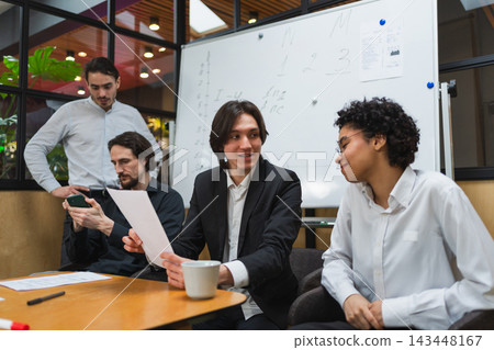 Teamwork brainstorm. Coworkers cooperating working together at office meeting. Colleagues discussing project ideas. Group of people in creative office discussing business. Young professional team 143448167