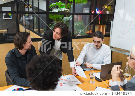 Teamwork brainstorm. Coworkers cooperating working together at office meeting. Colleagues discussing project ideas. Group of people in creative office discussing business. Young professional team Teamwork brainstorm. Coworkers cooperating working together at office meeting. Colleagues discussing project ideas. Group of people in creative office discussing business. Young professional team 143448174