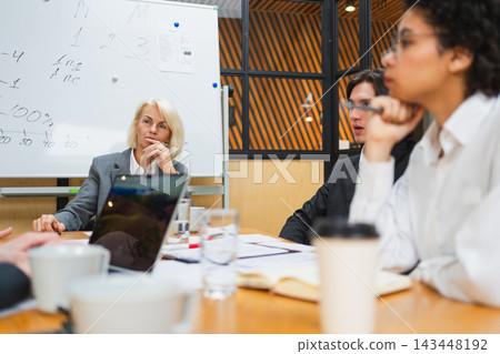 Teamwork brainstorm. Coworkers cooperating working together at office meeting. Colleagues discussing project ideas. Group of people in creative office discussing business. Young professional team Teamwork brainstorm. Coworkers cooperating working together at office meeting. Colleagues discussing project ideas. Group of people in creative office discussing business. Young professional team 143448192