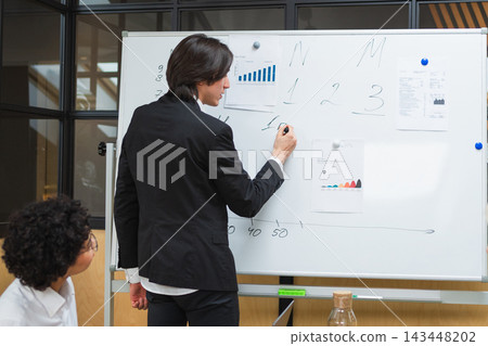 Teamwork brainstorm. Coworkers cooperating working together at office meeting. Colleagues discussing project ideas. Group of people in creative office discussing business. Young professional team 143448202