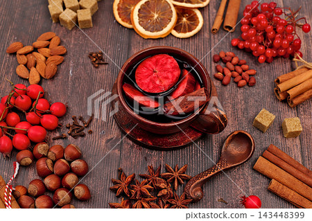 Autumn abstract composition featuring hot mulled wine, spices, burnt sugar, cloves, nuts, cinnamon, star anise, rowan berries, and rose hips, still life,Thanksgiving concept, seasonal background Autumn abstract composition featuring hot mulled wine, spices, burnt sugar, cloves, nuts, cinnamon, star anise, rowan berries, and rose hips, still life,Thanksgiving concept, seasonal background 143448399
