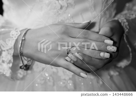 Black and white close-up of female hands wearing diamond engagement ring with decorated nail polish Black and white close-up of female hands wearing diamond engagement ring with decorated nail polish 143448666