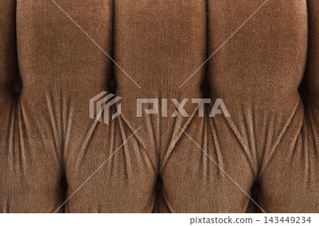 Comfortable brown tufted fabric sofa backrest with soft texture in a cozy living room setting Comfortable brown tufted fabric sofa backrest with soft texture in a cozy living room setting 143449234