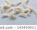 Snus pouches arranged on a white surface showing the different shapes and sizes during a casual indoor scene 143450011
