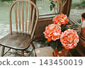 Beautiful indoor scene with orange flowers hydrangea and wooden chair in a serene setting 143450019