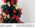 Decorated Christmas tree with red and gold ornaments in indoor space during holiday season 143450023