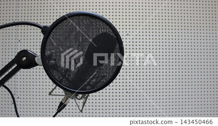 A round cloth pop filter in front of a microphone for reading text in a studio A round cloth pop filter in front of a microphone for reading text in a studio 143450466
