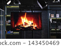 Studio Screen Monitor with Blurred Bonfire and Shelves with Thematic Items  143450469