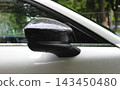 Close up stock photo of water drops on the glossy plastic cover of the car's side mirror 143450480