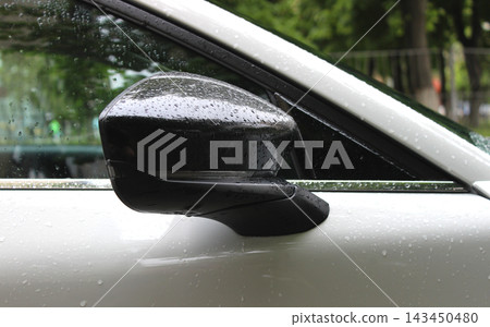 Close up stock photo of water drops on the glossy plastic cover of the car's side mirror Close up stock photo of water drops on the glossy plastic cover of the car's side mirror 143450480