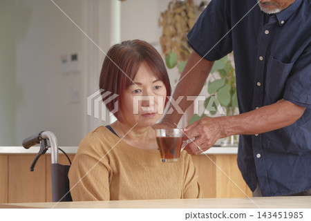 一位中年丈夫安慰坐輪椅的妻子。 一位中年丈夫安慰坐輪椅的妻子。 143451985