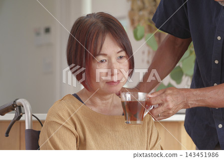 一位中年丈夫安慰坐輪椅的妻子。 143451986