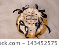 White birthday cake with black ribbons and candles on a gold plate, elegant party dessert with happy message in hearts. 143452575