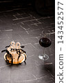 Elegant 30th birthday cake with white candles and black ribbon beside red wine glass on dark marble surface 143452577