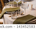 Elegant Formal Dinner Table Setting Featuring Crystal Glassware Green Napkins Gold Cutlery White Linens 143452583