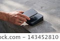 Person using a mobile device for contactless payment on a black terminal with contactless terminal transaction technology cashless electronic commerce wireless merchant checkout customer 143452810