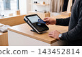 Customer paying with a credit card at a retail store checkout counter terminal transaction checkout purchase business merchant customer commerce technology electronic interaction consumer 143452814