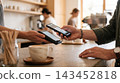 Customer paying for coffee with a smartphone at a cafe counter smartphone terminal contactless transaction business customer purchase checkout technology spending consumer electronic 143452818