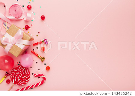Birthday party background, border of confetti, sweets, lollipops and gift on pink surface, copy space, top view Birthday party background, border of confetti, sweets, lollipops and gift on pink surface, copy space, top view 143455242