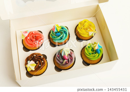 Set of colorful cupcakes in delivery box isolated on white background. Sweet snacks for holiday celebration, romantic date or birthday Set of colorful cupcakes in delivery box isolated on white background. Sweet snacks for holiday celebration, romantic date or birthday 143455431