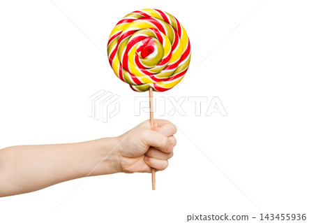 Child's hand holding big colorful lollipop candy on stick, isolated on white background. Child's hand holding big colorful lollipop candy on stick, isolated on white background. 143455936