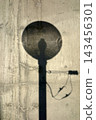 A wall with the silhouette of a streetlamp visible. 143456301