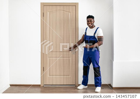 Smiling Black Male Professional In Work Attire Pointing At Door In Modern Office Setting, Showing Enthusiasm And Confidence, Ready To Assist Clients Or Visitors. Business Concept. Smiling Black Male Professional In Work Attire Pointing At Door In Modern Office Setting, Showing Enthusiasm And Confidence, Ready To Assist Clients Or Visitors. Business Concept. 143457107