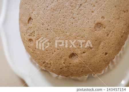 Close-up of the air bubbles and texture on the surface of a steamed bun. Close-up of the air bubbles and texture on the surface of a steamed bun. 143457154