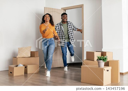 Joyful Young Black Couple, Smiling And Energetic, Moving Into New Home Together, Unpacking Boxes In Modern Interior, Celebrating New Beginning. Weight Loss Concept. Joyful Young Black Couple, Smiling And Energetic, Moving Into New Home Together, Unpacking Boxes In Modern Interior, Celebrating New Beginning. Weight Loss Concept. 143457196