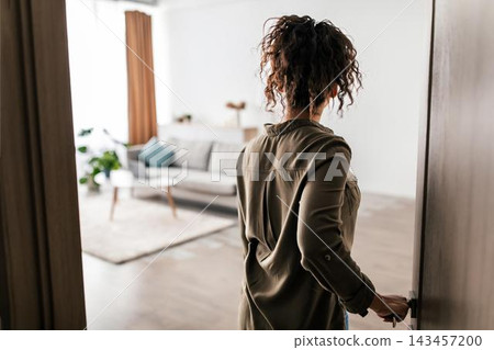 Curious Unrecognizable Woman Entering Modern Living Room With Natural Light, Exploring Space, Standing Near Door With Cozy Interior Design And Comfortable Atmosphere. Home Concept. Curious Unrecognizable Woman Entering Modern Living Room With Natural Light, Exploring Space, Standing Near Door With Cozy Interior Design And Comfortable Atmosphere. Home Concept. 143457200