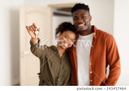 Smiling Young African American Couple Holding House Keys Together In New Apartment, Expressing Joy And Excitement For Home Ownership In Their Modern Living Space. Happy New Owners. Smiling Young African American Couple Holding House Keys Together In New Apartment, Expressing Joy And Excitement For Home Ownership In Their Modern Living Space. Happy New Owners. 143457464