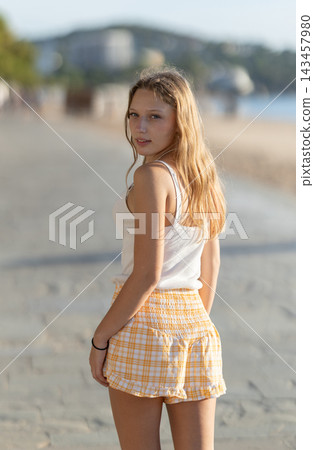 Girl walk through pedestrian promenade embankment Girl walk through pedestrian promenade embankment 143457980