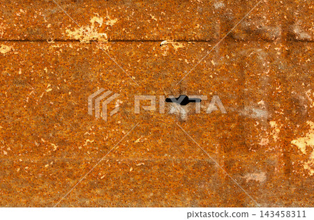 A rusty metal surface with a noticeable hole. The texture and color imply exposure to weather and time in an industrial area. The background highlights the decay process. A rusty metal surface with a noticeable hole. The texture and color imply exposure to weather and time in an industrial area. The background highlights the decay process. 143458311
