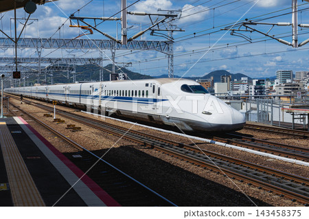 一列N700系列新幹線列車駛近姬路站，背景是壯麗的山景。 143458375