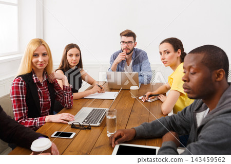 Six people work together around a table in an office. They look engaged in conversation, using laptops and notes. Everyone focuses on the discussion and sharing ideas about their project. Six people work together around a table in an office. They look engaged in conversation, using laptops and notes. Everyone focuses on the discussion and sharing ideas about their project. 143459562