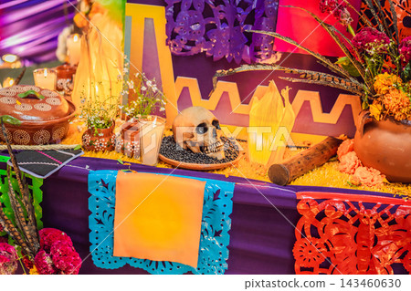 Decorative skull beside candles and flowers on a Mexican remembrance altar. Spanish text Queretaro, y entonces encontre Mexico means Queretaro, and then I found Mexico. 143460630