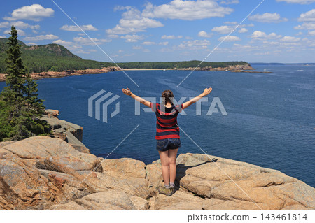 Teenager girl admiring the Aerial view of Sand Beach and Acadia National Park coastline from Otter Point Overlook, USA Teenager girl admiring the Aerial view of Sand Beach and Acadia National Park coastline from Otter Point Overlook, USA 143461814