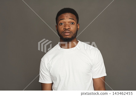 A young man poses alone against a plain background. He appears serious and thoughtful. This is part of a collage that shows various emotions and expressions. A young man poses alone against a plain background. He appears serious and thoughtful. This is part of a collage that shows various emotions and expressions. 143462455