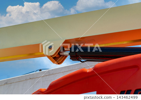 Hydraulic piston and metal joint on articulated aerial boom lift outdoors, heavy construction machinery designed for lifting, engineering, repair and industrial maintenance at height. 143462499