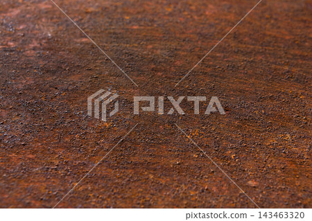 A close-up view shows a rusty metal surface displaying various textures and colors. The natural light highlights the rough and uneven surface. This creates a sense of depth and detail. A close-up view shows a rusty metal surface displaying various textures and colors. The natural light highlights the rough and uneven surface. This creates a sense of depth and detail. 143463320