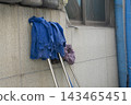Blue Cleaning Mops Hanging on Exterior Marble Wall for Drying Outside Building 143465451