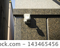 Surveillance CCTV Security Camera Installed on Marble Exterior Wall of Building 143465456