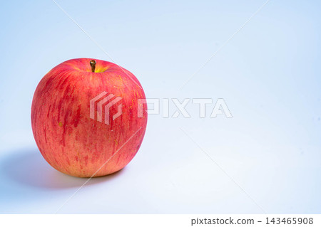 A photograph of a Sun Tsugaru apple against a white background. 143465908