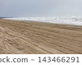 The scenery of the sandy beach stretching along the coast and the waterline. 143466291