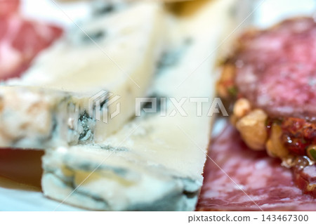 Close-up view of sliced blue cheese and cured meats on a platter 143467300