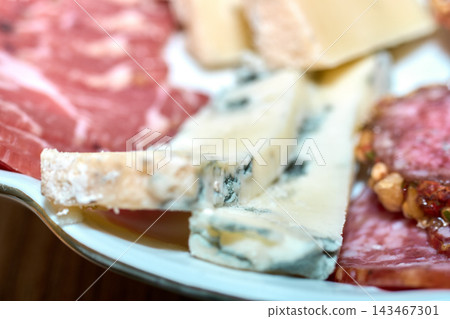 Close-up of assorted cheese and cured meat platter for party appetizers Close-up of assorted cheese and cured meat platter for party appetizers 143467301