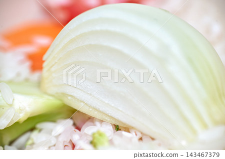 Close-up shot of a sliced fresh white onion wedge with rice and vegetables Close-up shot of a sliced fresh white onion wedge with rice and vegetables 143467379